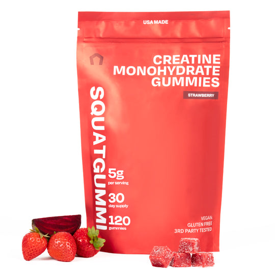 Red package of SquatGummie Creatine Monohydrate Gummies with strawberries and gummies on a white background